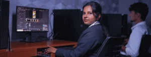 Female student working at a computer workstation in a video editing lab