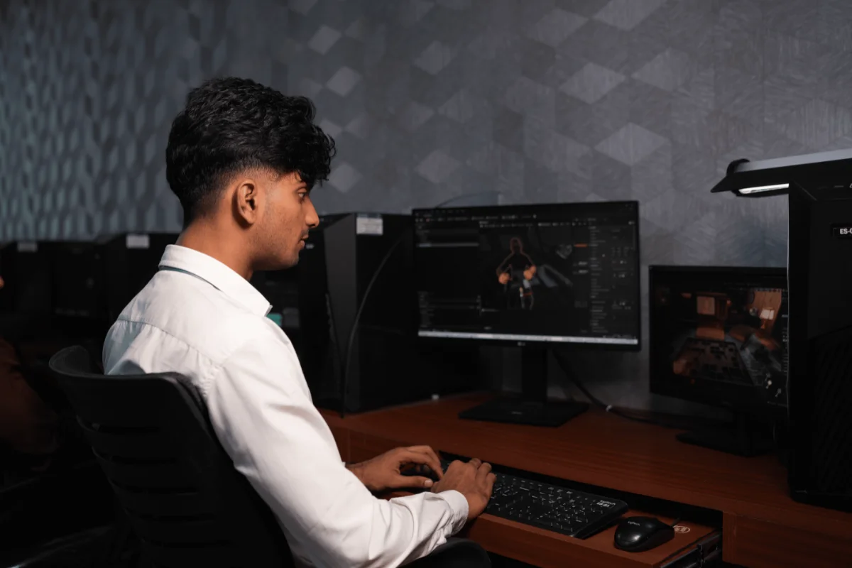 Side view of a student operating video editing software in a modern post-production computer lab